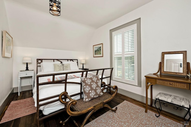 bedroom with lofted ceiling, baseboards, and wood finished floors