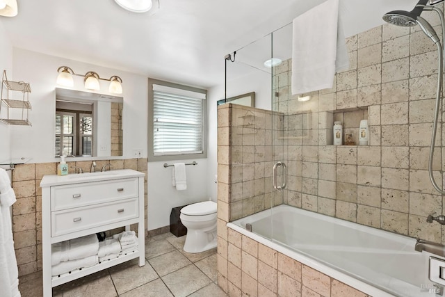 bathroom featuring tiled shower / bath combo, tile patterned flooring, toilet, and vanity