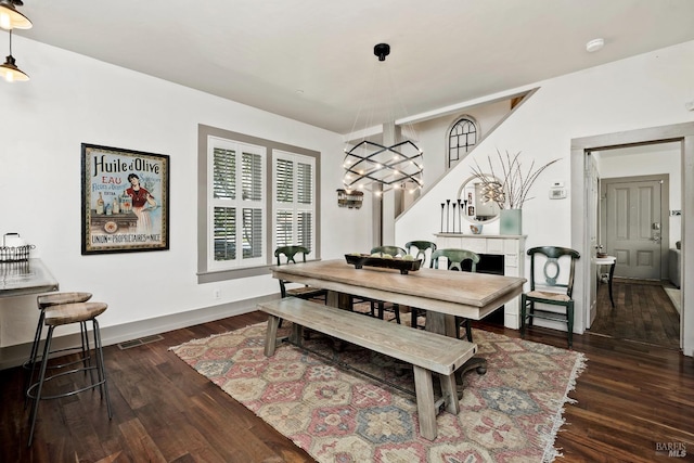 dining space with wood finished floors, visible vents, and baseboards