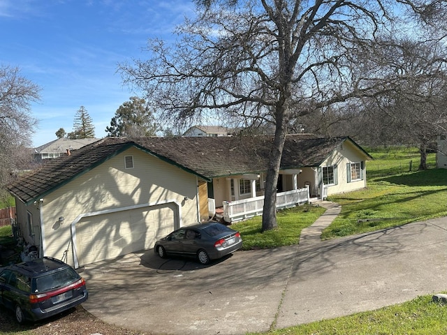 ranch-style house featuring driveway, an attached garage, a porch, and a front lawn