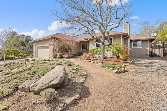 ranch-style home with a garage, concrete driveway, and a chimney