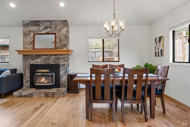 dining space featuring light wood-type flooring, recessed lighting, baseboards, and a stone fireplace