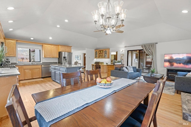 dining room featuring vaulted ceiling, light wood-type flooring, an inviting chandelier, and recessed lighting