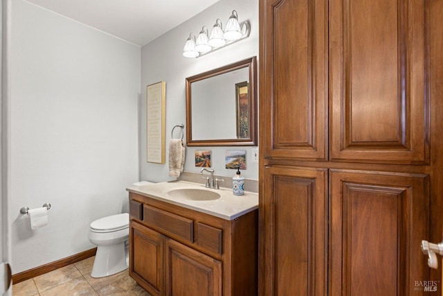 bathroom featuring toilet, tile patterned flooring, baseboards, and vanity