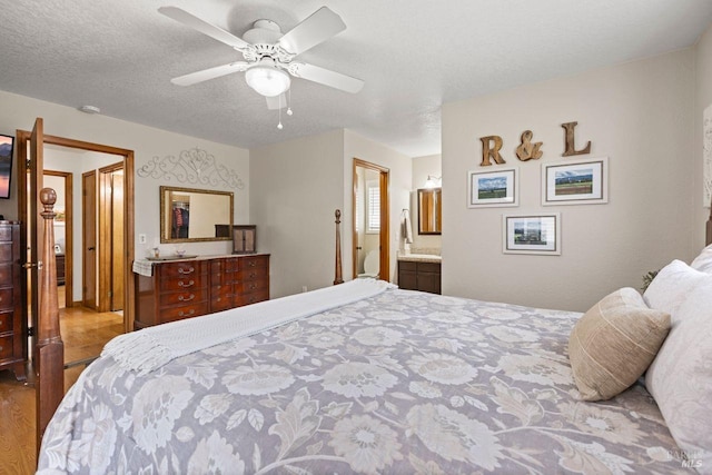 bedroom with a ceiling fan, a textured ceiling, ensuite bathroom, and wood finished floors