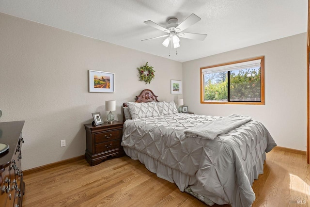 bedroom with light wood-type flooring, ceiling fan, and baseboards