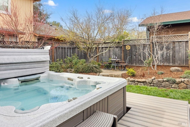 deck featuring a fenced backyard and a hot tub