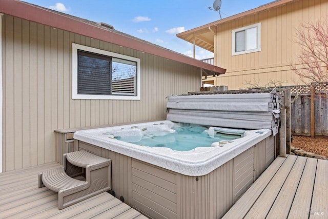 wooden terrace with a covered hot tub and fence