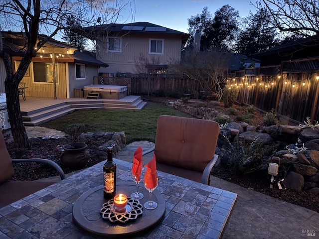 view of patio featuring a fenced backyard, a wooden deck, and a hot tub