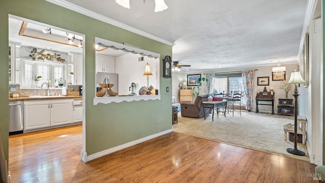 kitchen featuring appliances with stainless steel finishes, a sink, a ceiling fan, and white cabinetry