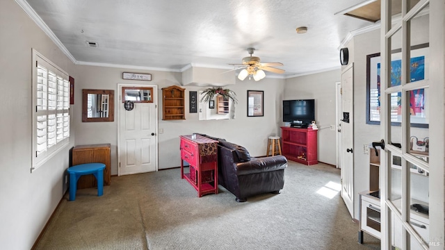 carpeted living room with visible vents, ornamental molding, and a ceiling fan