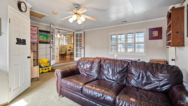 living room with carpet floors, visible vents, ornamental molding, and a ceiling fan