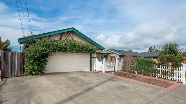 view of front of house featuring concrete driveway, an attached garage, and fence