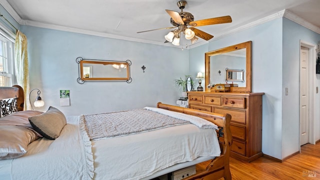 bedroom featuring a ceiling fan, light wood-type flooring, crown molding, and baseboards