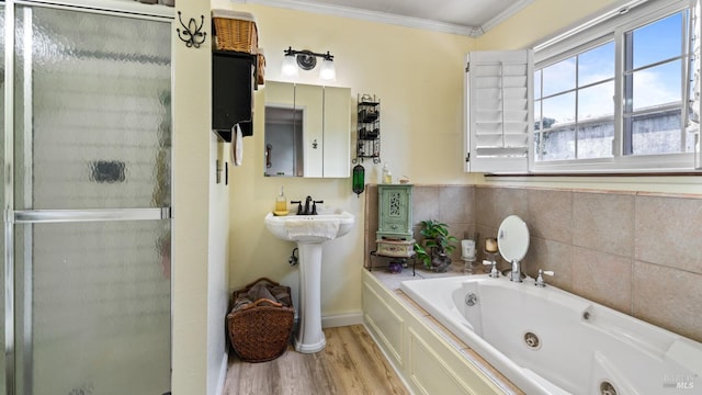 full bath with a stall shower, crown molding, a jetted tub, and wood finished floors