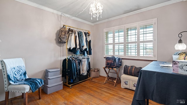 walk in closet with an inviting chandelier and wood finished floors