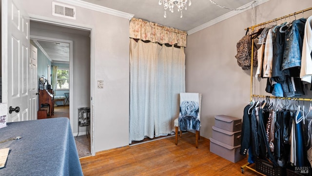 spacious closet featuring visible vents, a notable chandelier, and wood finished floors