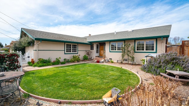 ranch-style home featuring fence, a front lawn, and stucco siding