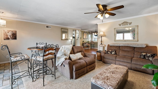 living room featuring ceiling fan with notable chandelier, baseboards, visible vents, and crown molding