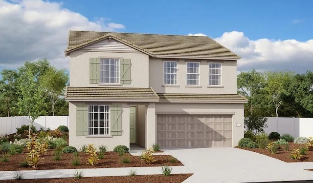 traditional-style house featuring a garage, fence, concrete driveway, and stucco siding