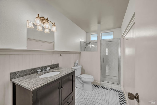 bathroom featuring tile patterned flooring, a wainscoted wall, a shower stall, and toilet