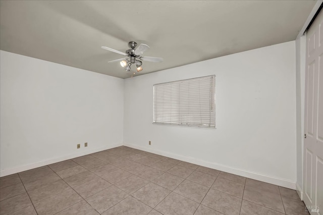 empty room with ceiling fan and baseboards