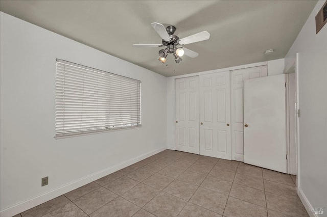 unfurnished bedroom featuring light tile patterned floors, baseboards, and a closet