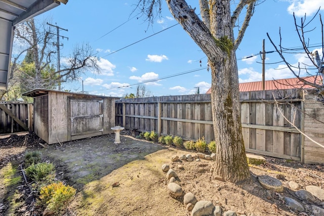 view of yard with a shed, an outdoor structure, and a fenced backyard