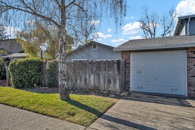 garage featuring driveway and fence