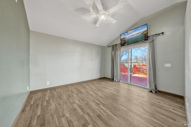 empty room with lofted ceiling, wood finished floors, a ceiling fan, and baseboards