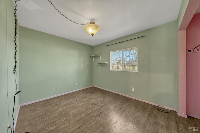 unfurnished bedroom featuring visible vents, baseboards, and wood finished floors