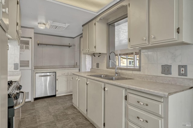 kitchen with stainless steel appliances, light countertops, a sink, and decorative backsplash