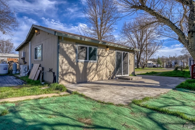 rear view of house with a patio and a lawn