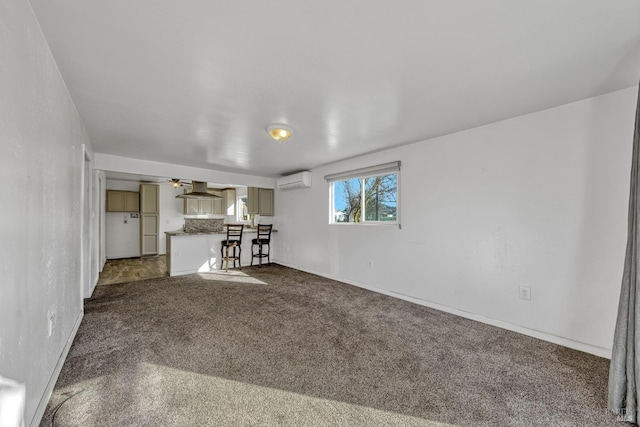 unfurnished living room featuring ceiling fan, dark colored carpet, and a wall unit AC