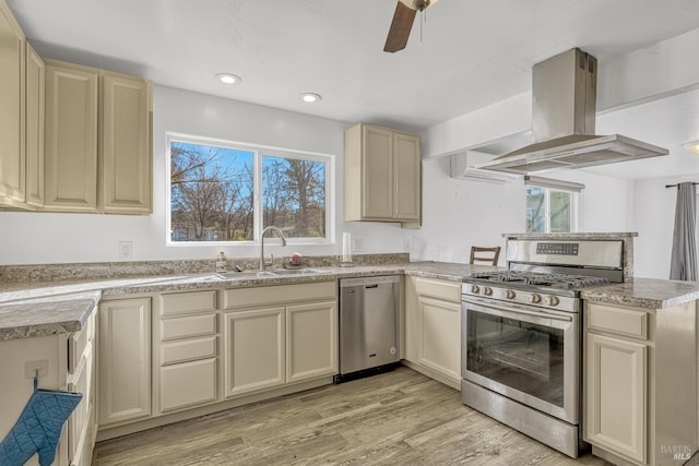 kitchen with stainless steel appliances, cream cabinets, a sink, and ventilation hood