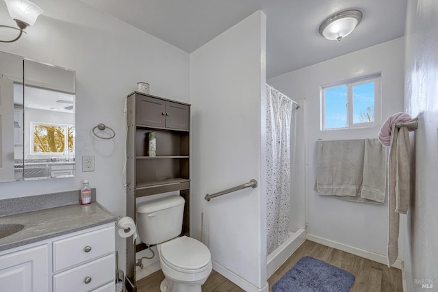 full bathroom with a shower with shower curtain, a healthy amount of sunlight, toilet, and wood finished floors