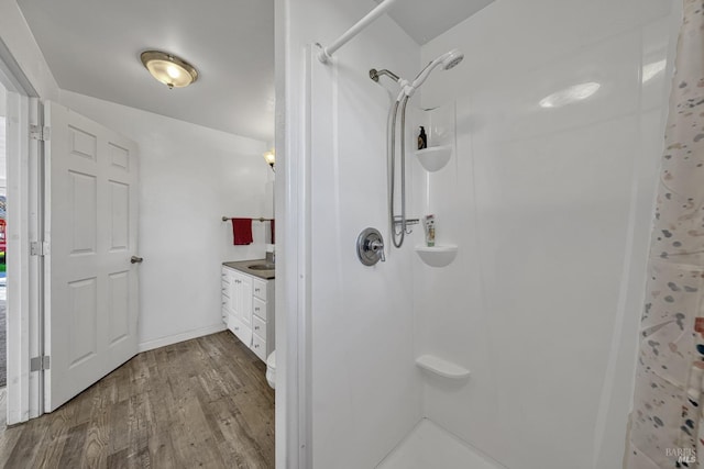 full bathroom with baseboards, wood finished floors, vanity, and a shower with curtain