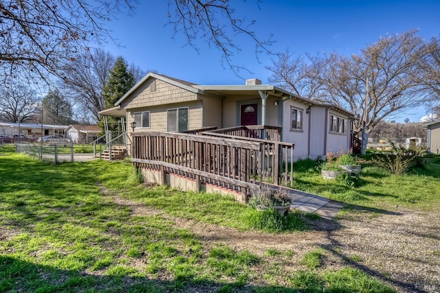 view of front of home featuring a chimney and a front lawn