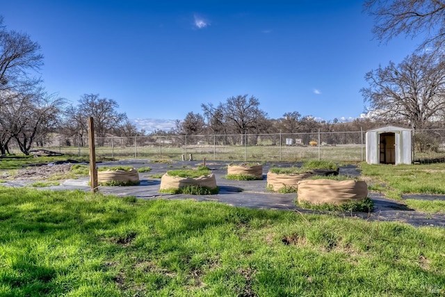 view of yard with a storage shed, fence, and an outdoor structure