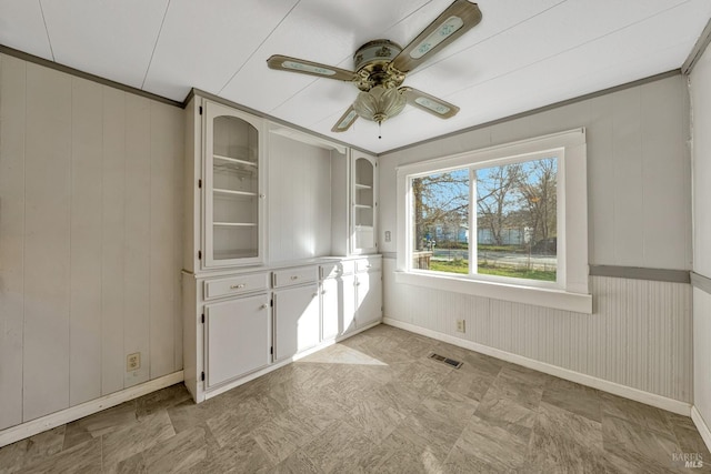 interior space featuring baseboards, visible vents, and a ceiling fan