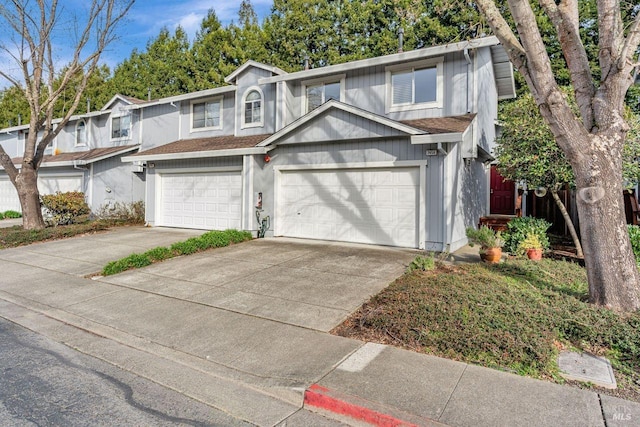 view of front of house with a garage, roof with shingles, and driveway