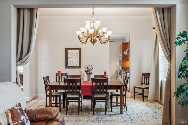 dining room with ornamental molding, a chandelier, and baseboards