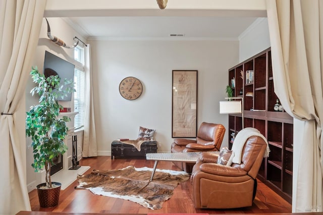 sitting room featuring ornamental molding, wood finished floors, and visible vents