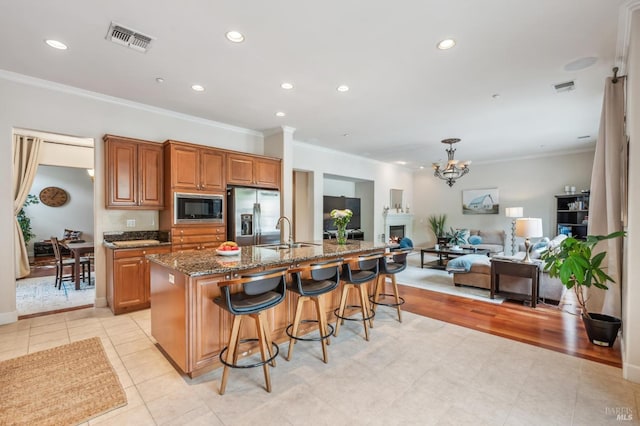 kitchen featuring visible vents, built in microwave, open floor plan, and stainless steel fridge with ice dispenser