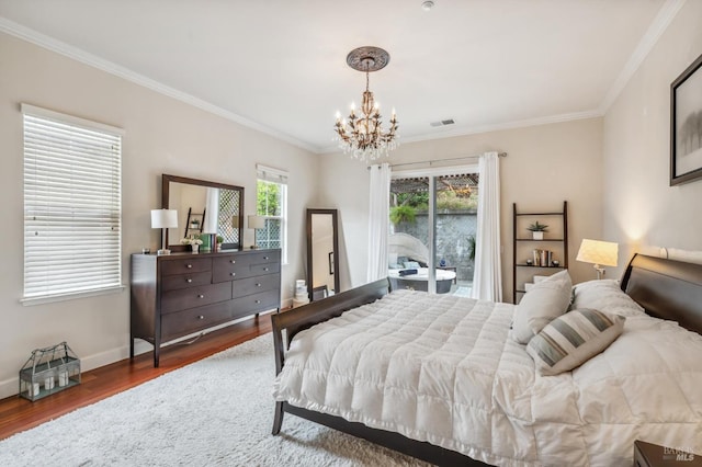 bedroom with a notable chandelier, baseboards, wood finished floors, and crown molding