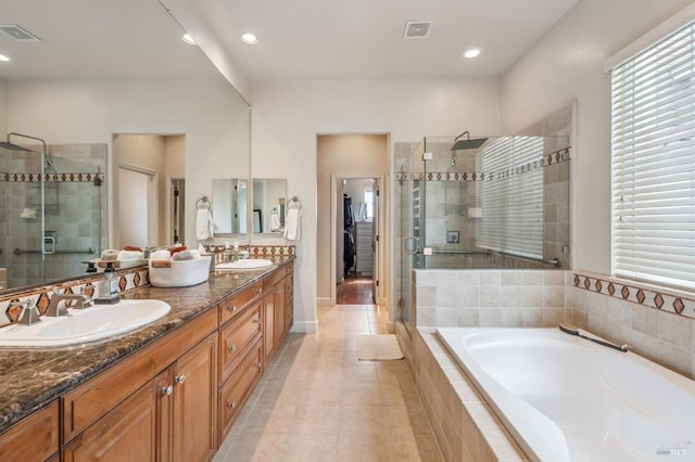 full bath with a bath, a shower stall, visible vents, and a sink