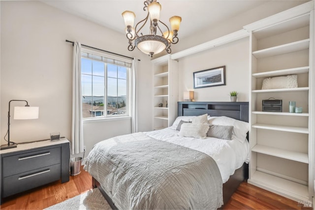 bedroom with an inviting chandelier and wood finished floors