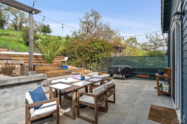 view of patio featuring a grill, fence, and outdoor dining area