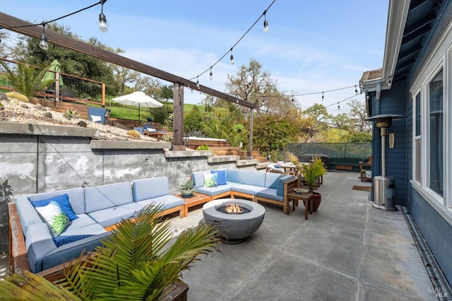 view of patio with an outdoor living space with a fire pit and fence