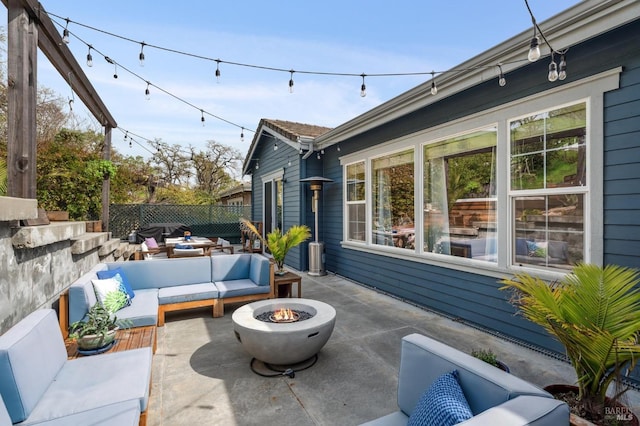 view of patio / terrace with an outdoor living space with a fire pit and fence